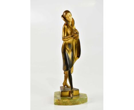An Art Deco bronzed spelter figure of a maiden wearing a cloak with ivorine head, on triangular onyx plinth base, height 22cm