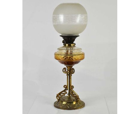 An early 20th century oil lamp with cut glass reservoir, the brass mount stamped 'Young', on a brass plated base with relief 
