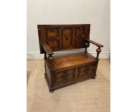 An early 20th century oak monk's bench with hinged seat, width 106, depth 51, height 76cm.