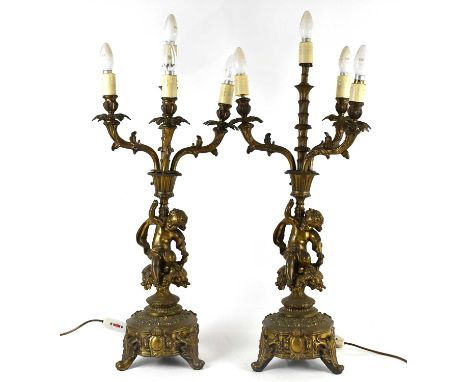 A pair of Victorian gilt metal four branch candelabra, each representing a seated cherub supporting the branches, height incl