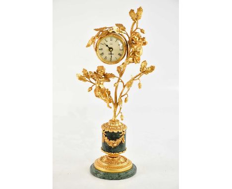 L'ORIGINALE; a reproduction gilt metal and marble figural mantel clock, with cherubs climbing the branches flanking the dial 