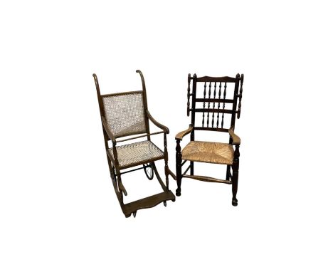 A 19th century rush seated spindle back elbow chair and a vintage invalid's chair with cane seat (2).
