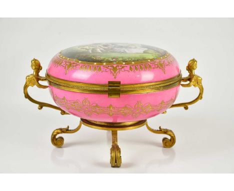 A Continental gilt metal mounted enamel casket of circular form, decorated with classical figures in a landscape and winged t