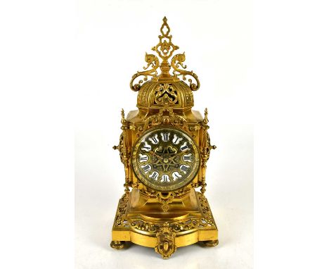 A reproduction French style gilt brass clock with finial above the applied Roman numeral dial, height 40cm.