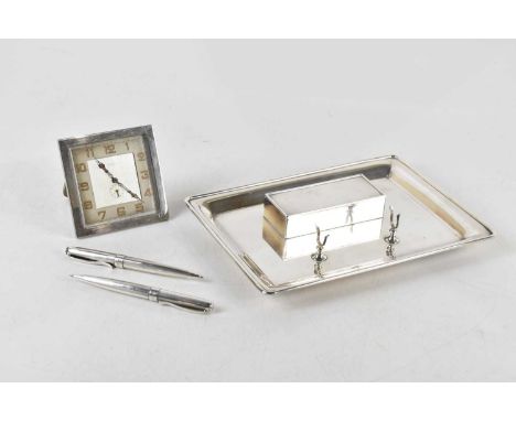 A silver plated rectangular desk stand, with a rectangular hinged box enclosing three compartments, with pen stand, on four b