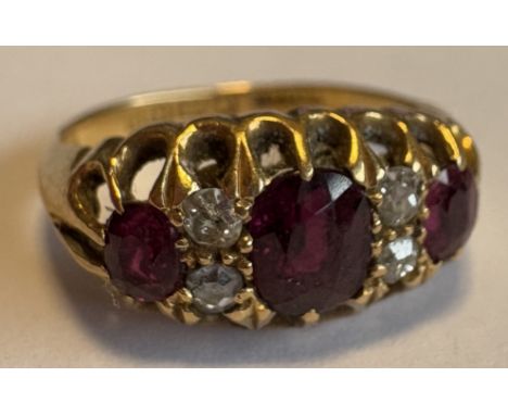 A small ruby and diamond seven-stone ring in 18 carat gold claw mount. Approx. ring size K. Approx. 3 grams. Est. £150 - £200