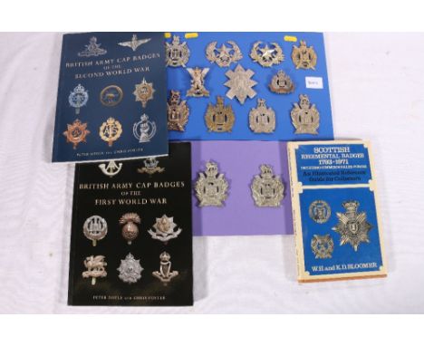 Two boards containing 13 cap badges including King's Own Scottish Borderers, Camerons, Suffolk Regiment etc. also three volum