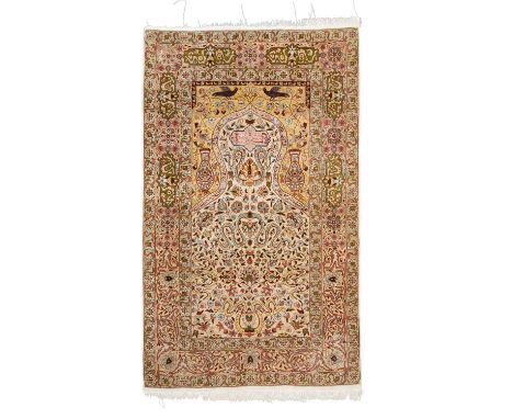 Orientteppich aus Seide. 20. Jh., ca. 150x94 cm. Gebetsteppich mit hellbeigefarbenem Giebelfeld. Die oberen beiden Ecken sind