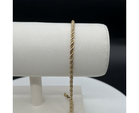 An 18ct yellow and white gold diamond cut rope chain bracelet,
bracelet will need a solder repair,
8 inches long,
hallmarked 