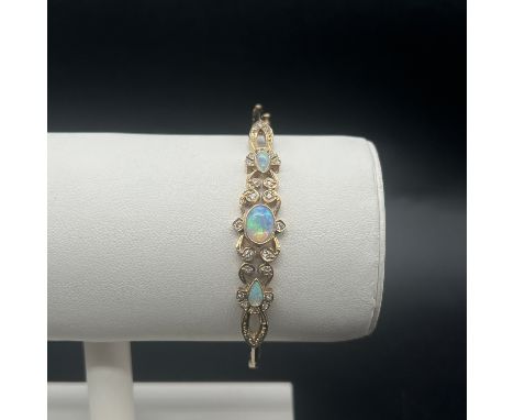 A solid 9ct yellow gold opal and diamond bangle,
65mm x 56mm,
very nice condition,
10.76 grams in weight