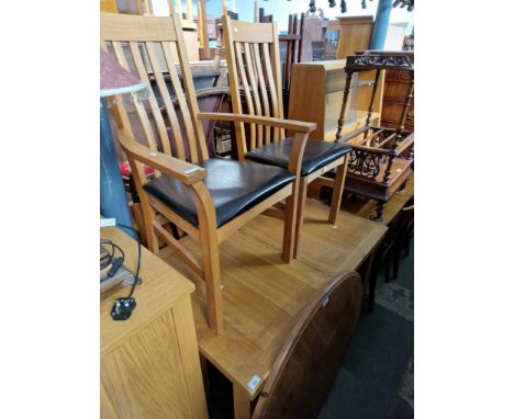 A modern light oak dining table and four chairs. 