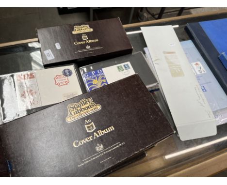 Four albums of first day covers in Stanley Gibbon's albums together with a J Dunlop Isle of Man TT print, an envelope of firs