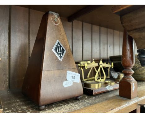 A metronome and a post office style weighing scale with weights 