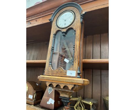 A wall clock with inlaid front, with a pendulum 