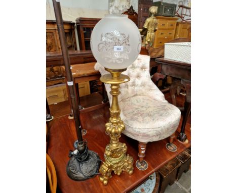 A floor lamp with gilt pedestal base and glass shade. 