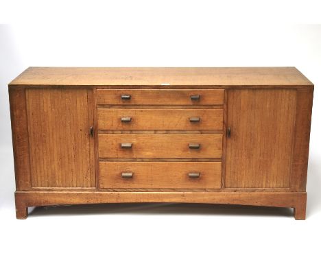 A mid-century oak Art Deco sideboard. With four graduating drawers to the centre flanked with tambor side doors opening to re