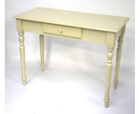 A vintage wooden side table. Painted white, with a frieze drawer, raised on turned and tapered supports, L99cm x D46.5cm x H7