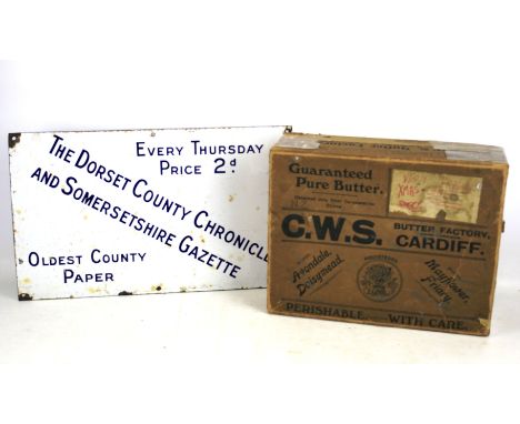 An enamel advertising sign and vintage 'Butter Box'. The sign promoting 'The Dorset County Chronicle and Somersetshire Gazett