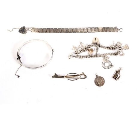 An assortment of silver jewellery. To include a charm bracelet, bangle, gate bracelet, 96.8 grams.