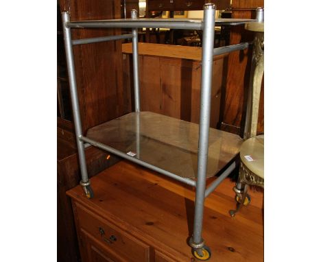 A 1950s grey painted tubular metal and brushed steel two-tier medical trolley, raised on roller castors, width 60cm