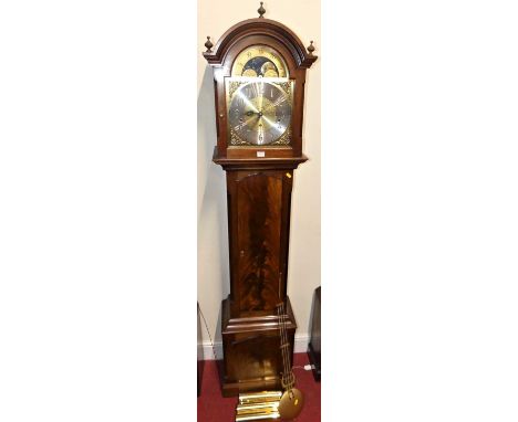 A contemporary mahogany and flame mahogany longcase clock, having arched brass and sivered moon phase dial, striking and chim