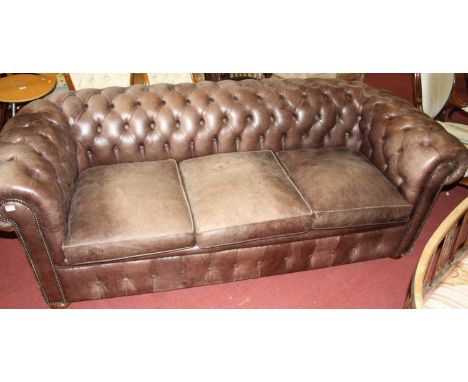 A contemporary faded buttoned leather three-seater Chesterfield sofa-bed, with squab cushions, w.210cmHeavy discolouration to