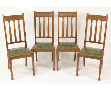 A set of four early 20th century walnut dining chairs by Shapland &amp; Petter, having slightly recessed circular concave bar