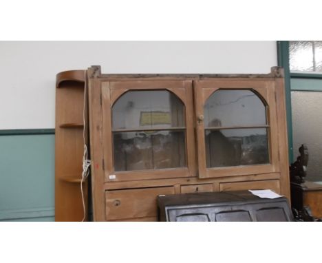 Stripped pine cupboard unit (54" wide), fitted 3 small central drawers below the 4 glazed panelled shelf display unit with do