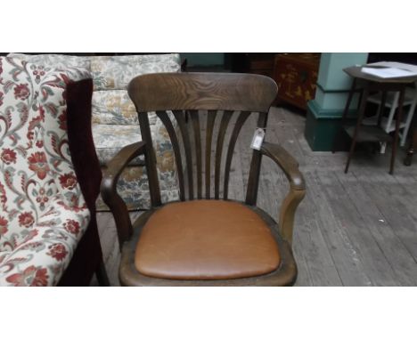 Oak swivel office chair, the padded inset seat in light brown leather all on 4 splayed feet on castors