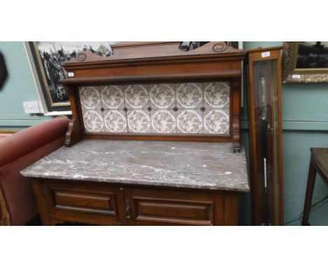 Edwardian mahogany framed washstand on delicate turned feet on pot castors with 12 floral tiles to back and veined light brow
