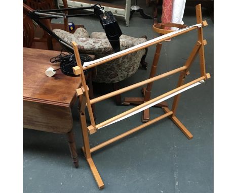 A wooden cross stitch frame together with an embroidery frame and a magnifying lamp 