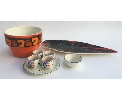 A selection of Poole pottery to include an orange abstract design planter, a Delphis design platter, an egg cup set and pin d