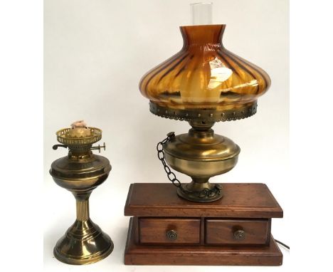 A converted oil lamp set on small set of mahogany desk drawers, together with an oil lamp and green glass vase 