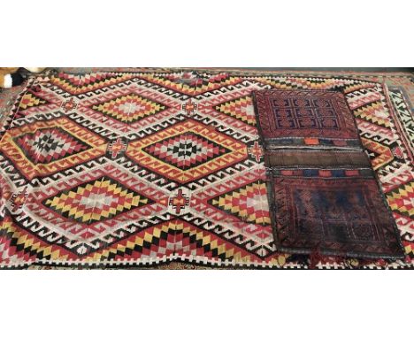 A kilim rug, in red and yellow, pattern of tessellated hooked lozenges, 270x155cm; together with a West Persian carpet saddle