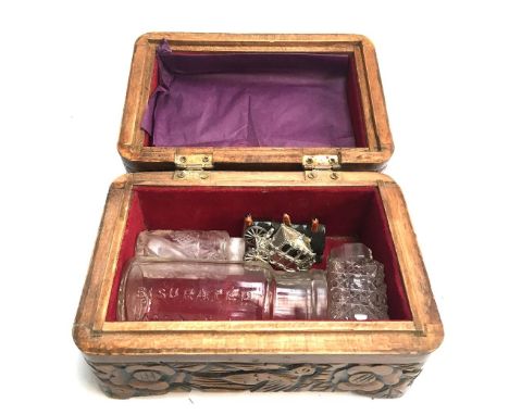 A small hardwood box profusely carved with birds and flowers, containing two small cut glass scent bottles; a tiny ceramic ho