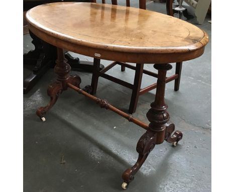 An oval side table, quartered burr walnut veneer top, having floral marquetry inlay, on turned and carved supports, joined by