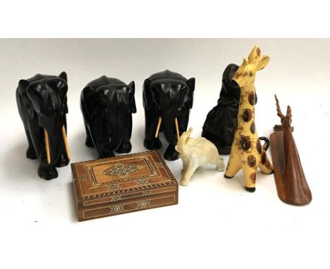 Three hardwood carved African elephants, a ceramic elephant and giraffe figurine, carved nativity figure etc 