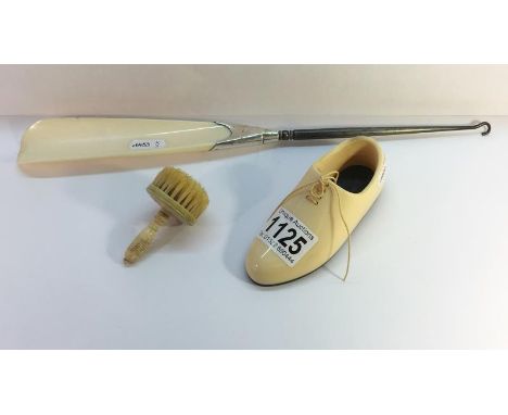 A bone shoe, a bone brush and a bone shoe horn button hook with bone horn and silver mount, hall marked E B London 1913.