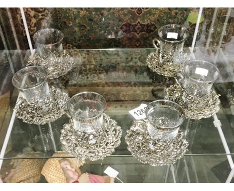 A set of 6 glass and metal cups and saucers.