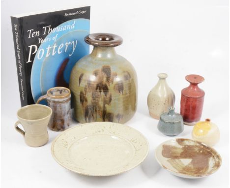 A collection of nine studio pottery items including a Leach Pottery waisted teacup, olive glaze, 8cm, a shallow stoneware dis