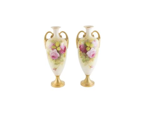  A PAIR OF ROYAL WORCESTER AMPHORA SHAPED PORCELAIN VASES, signed A. Shuck, each with gilt handles and circular foot, the bod