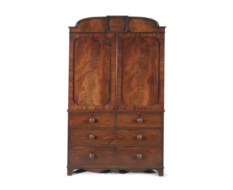 A GEORGE IV MAHOGANY GENTLEMAN’S WARDROBE, in two sections, surmounted with an arched capital, above twin fielded panel doors