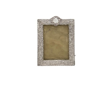 A SILVER EMBOSSED AND PIERCED EASEL BACK PHOTOGRAPH FRAME, Birmingham 1908, of rectangular form, surmounted with vacant carto