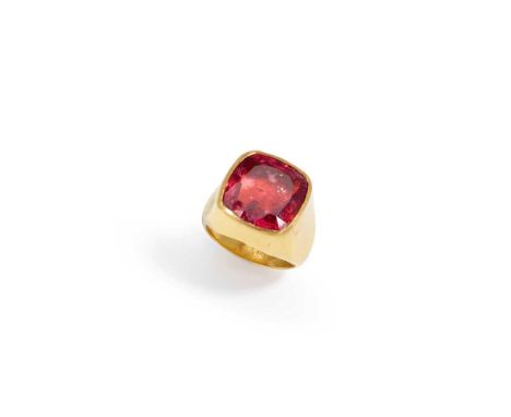 A pink tourmaline dress ring The cushion-shaped pink tourmaline collet-set in an 18ct gold closed back mount, to a tapered ho