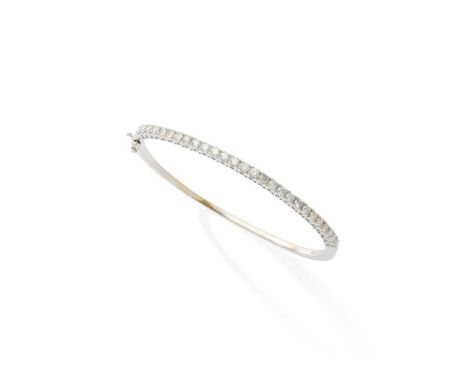 A diamond bangle The hinged bangle set to the front with a uniform line of brilliant-cut diamonds in four-claw mountsDimensio