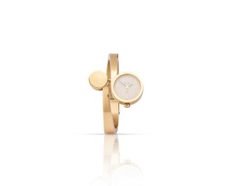 Bulova: a watch bangle Of crossover design, one terminal the watch head, the other a polished gold disc, the round champagne 