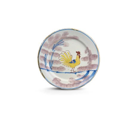 A Bristol delftware 'Farmyard' plate, c.1720-30, painted in yellow, red and blue with a standing cockerel flanked by trees sp