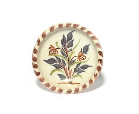 A small delftware shallow bowl or saucer dish, late 17th century, painted in blue, green, red and manganese with a stylized f