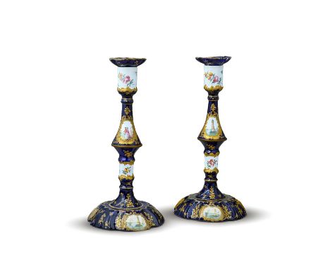 A pair of Bilston enamel candesticks, c.1770, with removable drip pans, the swollen stem painted with panels of figures and l