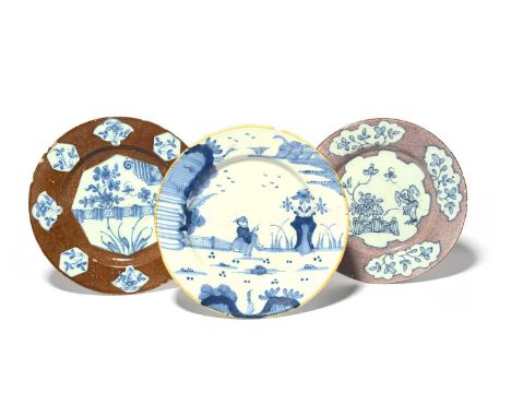 Three delftware plates, c.1750-70, one probably London and painted with an ornamental fence in an octagonal panel reserved on